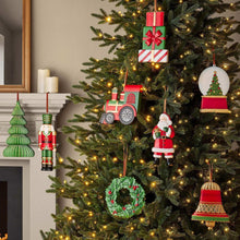 Christmas ornament set hanging on a tree, with wreath, bell, train, gifts