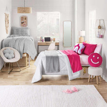Oversized plush blanket in gray with ribbed stripe texture, draped over bed