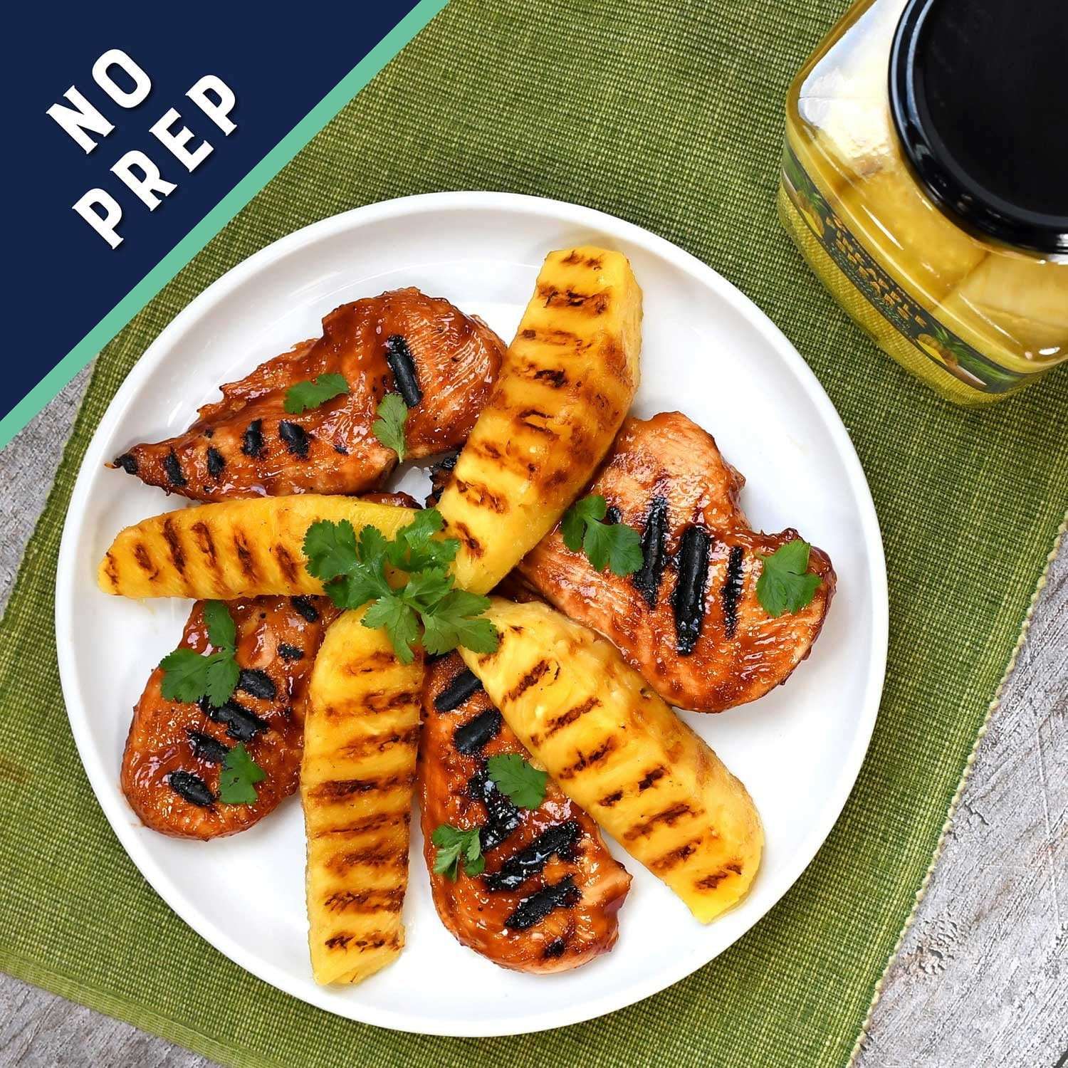 Grilled pineapple spears with herbs on a plate, with jar in corner