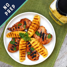 Grilled pineapple spears with herbs on a plate, with jar in corner