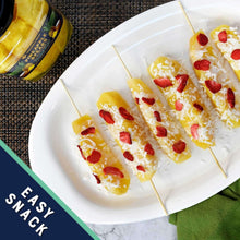 Pineapple spear halves topped with shredded coconut and raspberries on a plate