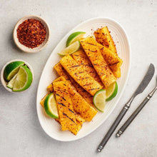 Seasoned grilled pineapple spears with lime wedges on a platter