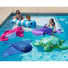 Blue stingray-style pool float in a swimming pool with families playing