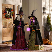 Two pre-lit witch figurines in dark robes with glowing purple crystal ball