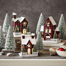 Pre-lit red plaid village set with white fences, miniature houses, and snowy trees