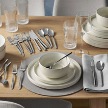 Stainless steel flatware set with modern handles, gold finish on table setting
