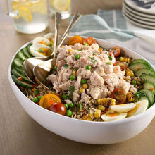 Bowl of shredded chunk chicken with corn, peas, tomatoes, and sliced cucumbers