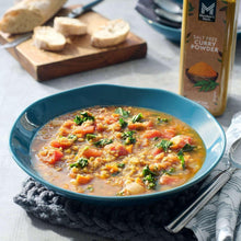 Salt-free curry powder over lentil soup with herbs; curry powder bottle nearby
