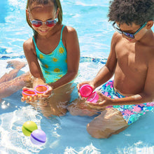 Kids holding reusable self-sealing water balloons and open valve cups, assorted colors