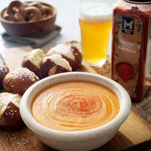Spanish-style paprika seasoning jar shown with a bowl of orange dip