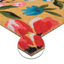 Coir doormat corner close-up with red floral letters and curved edge