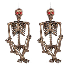 Gold-tone skeleton decoration set with glowing red eyes, angled full body view