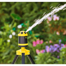 Telescoping tripod sprinkler close-up with continuous water stream from yellow nozzle