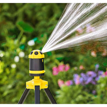 Telescoping tripod sprinkler close-up with water spray arc from the yellow top nozzle