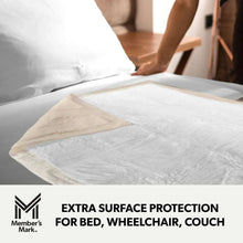 Beige underpad with protective backing laid flat on a bed surface.