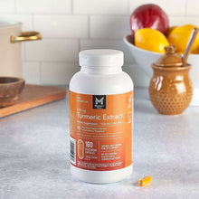 Turmeric extract supplement bottle with orange label and loose capsules on countertop