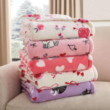 Stacked lounge throws with heart patterns in pink, purple, and red