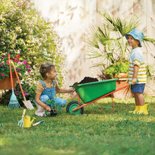 Children’s green wheelbarrow with orange handle and kid garden tools, on grass