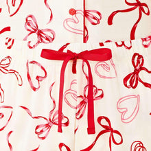 Close-up of pajama shorts waistband with red bow print and ribbon drawstring