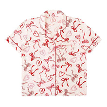 Short-sleeve pajama top back with red bow pattern and contrast piping