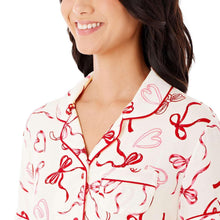 Notch-collar pajama top with red bow print and contrast piping, button placket
