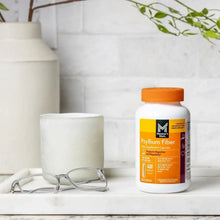 Psyllium fiber capsule bottle with orange cap on a white surface