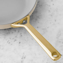 Cream ceramic pot handle with gold-tone frame and metal rivets