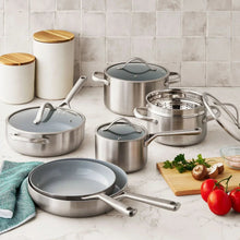 Stainless steel cookware set with dark lids and serving pots, ceramic-coated interiors