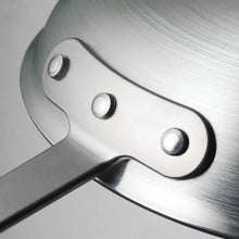 Brushed metal fry pan exterior with three rivets along the handle mount