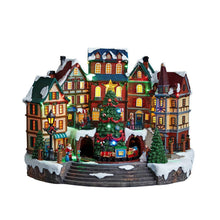 Pre-lit musical village scene with colorful houses, lit tree, and front walkway
