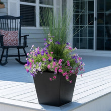 Black square planter with pink and purple flowers and tall green grass