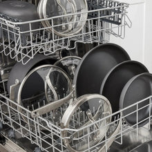 Cookware set loaded in dishwasher racks, dark gray pots and pans with stainless parts