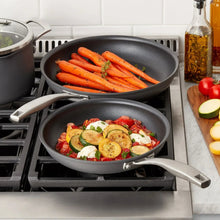 Nonstick frying pans with food, dark gray pans with stainless handles and vented racks