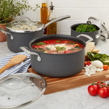 Nonstick cooking pot and saucepan with lids, dark gray, filled with soup and greens