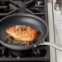 Hard anodized nonstick skillet with helper handle, gray interior, on stovetop