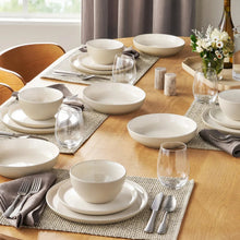 Stoneware dinnerware set with taupe bowls and plates arranged on a table