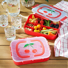 Red Snackle lunch box open with divided sections for fruits and snacks
