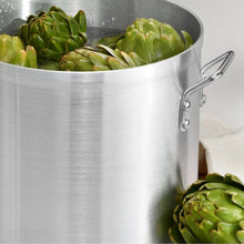 Aluminum stock pot with two side handles, filled with vegetables