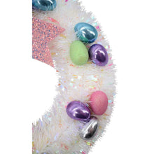 Tinsel bunny wreath close-up with pastel and purple-blue egg ornaments near pink bow