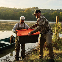 Two heavy-duty storage totes with orange lids near a lakeshore