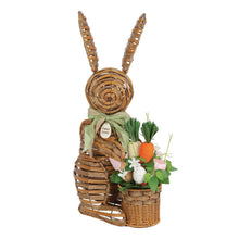 Woven bunny porch decoration holding a spring basket with flowers, eggs, and a carrot