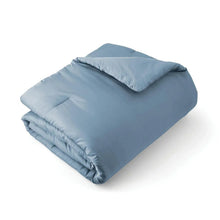 Blue comforter set with matching pillow shams, folded for storage