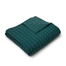 Teal quilt with small grid-and-stitch pattern folded neatly