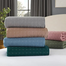 Assorted quilt set stacks: white, tan, and blue quilts with subtle stitched stripe pattern