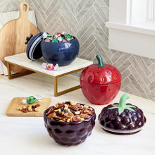 Stoneware berry canister set with three lidded canisters: blue, red, and purple.