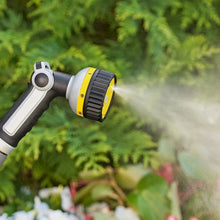 Watering hose sprayer gun with yellow-and-gray nozzle releasing mist