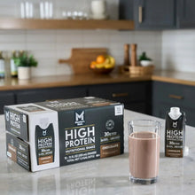 Chocolate high protein shake cartons with a glass of shake on countertop