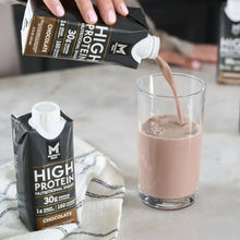 Chocolate high protein shake poured from carton into a glass