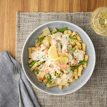 Gray reactive stoneware pasta bowl filled with fusilli, seafood, herbs, and lemon