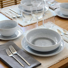 Gray reactive stoneware pasta bowl with speckled glaze on a dinner place setting